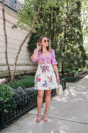 Feminine fashion blogger in Chicago styling a tie-front top with a floral skirt.