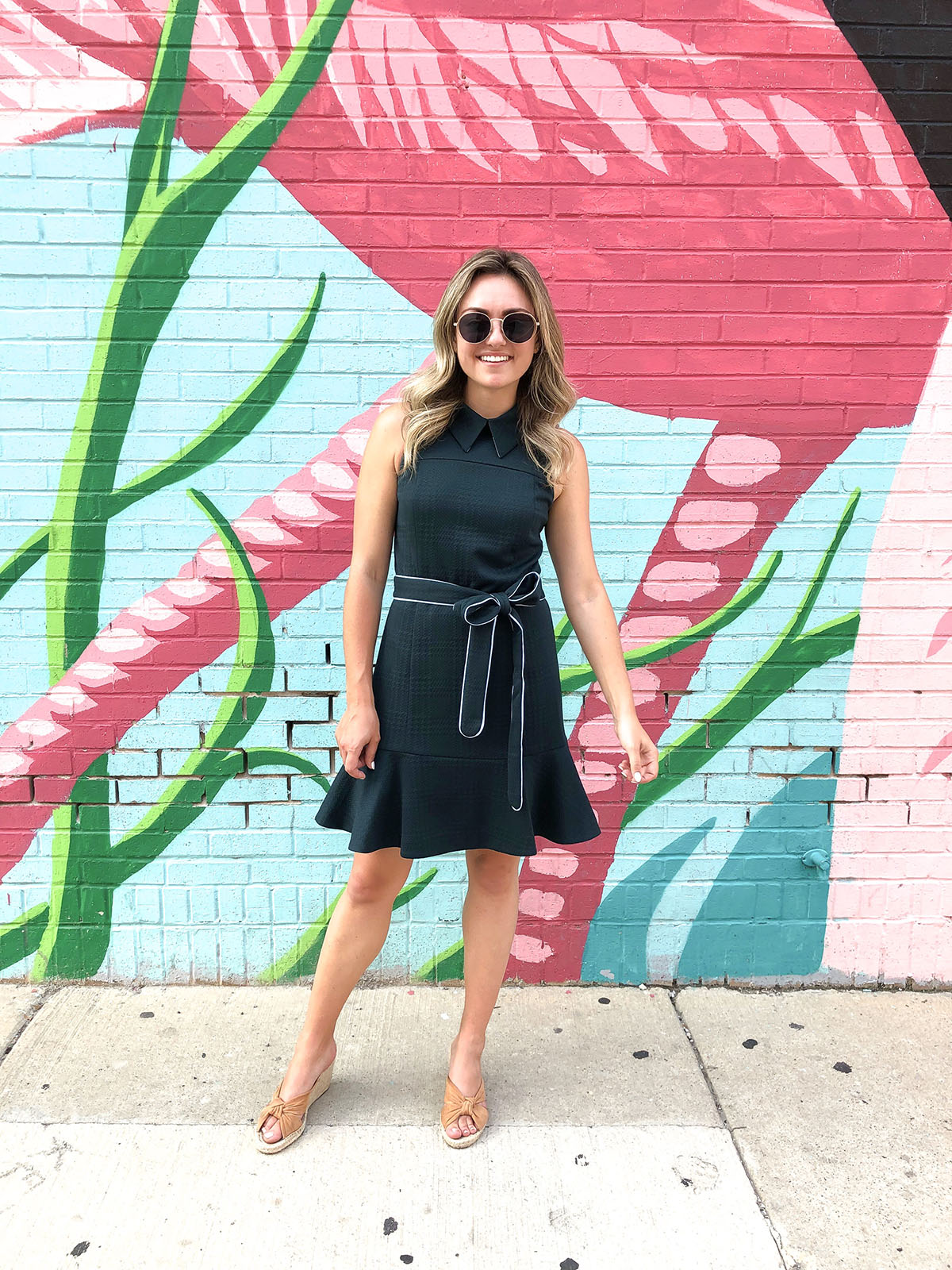 Chicago blogger Jessica Sturdy of Bows & Sequins in front of the pink flamingo wall in River North wearing a preppy green dress with a cute collar and ruffle hem.