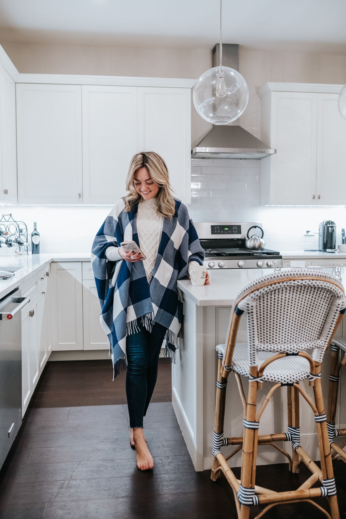 Chicago lifestyle blogger wearing a Vineyard Vines gingham buffalo check cape next to Serena & Lily Riviera Counter Stools in Navy Promo Code.