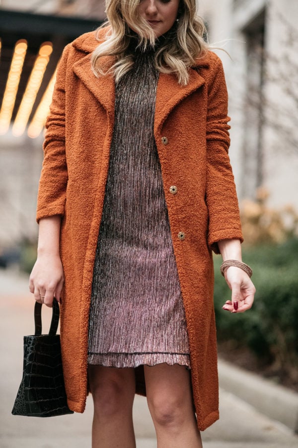 Fashion blogger wearing a sparkly dress with a teddy coat.