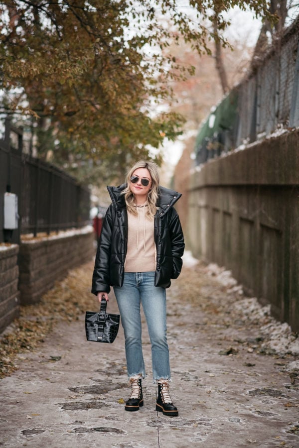 Chicago style blogger Bows & Sequins wearing a puffy leather jacket with a camel cashmere hoodie, raw hem cropped jeans, and leather shearling hiking boots.