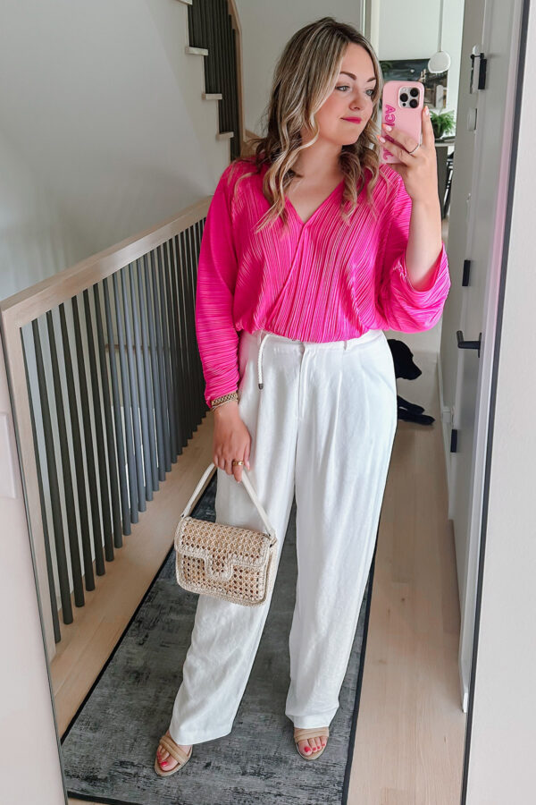Chicago influencer Jessica Sturdy styling a Good American pink Sculpt top with white pants and a Caterina Bertini raffia bag.