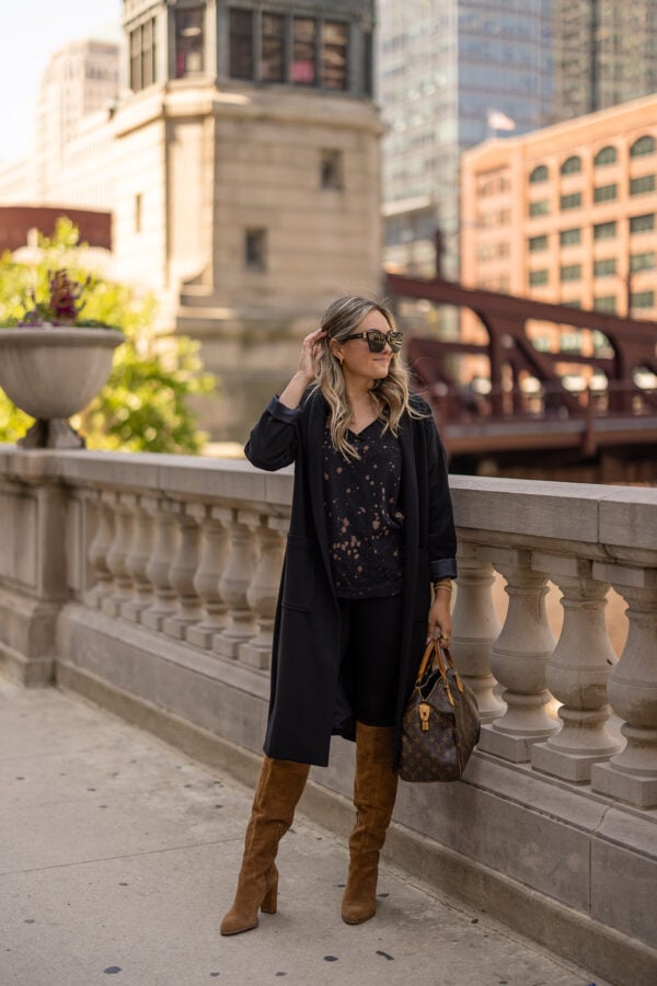 Top Chicago blogger Jessica Sturdy of Bows & Sequins wearing a fall outfit by the Chicago riverfront bridges. Jessica is wearing a black duster cardigan and slouchy suede cognac boots.