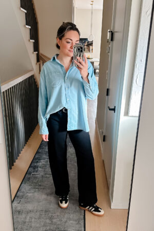 Chicago blogger Bows & Sequins styling an oversized denim shirt with black jeans and Adidas Samba sneakers.