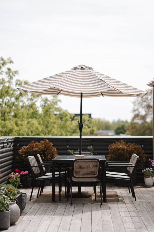 Chicago influencer Bows & Sequins shares her chic rooftop garden with a modern, affordable dining set from Target with a striped patio umbrella.