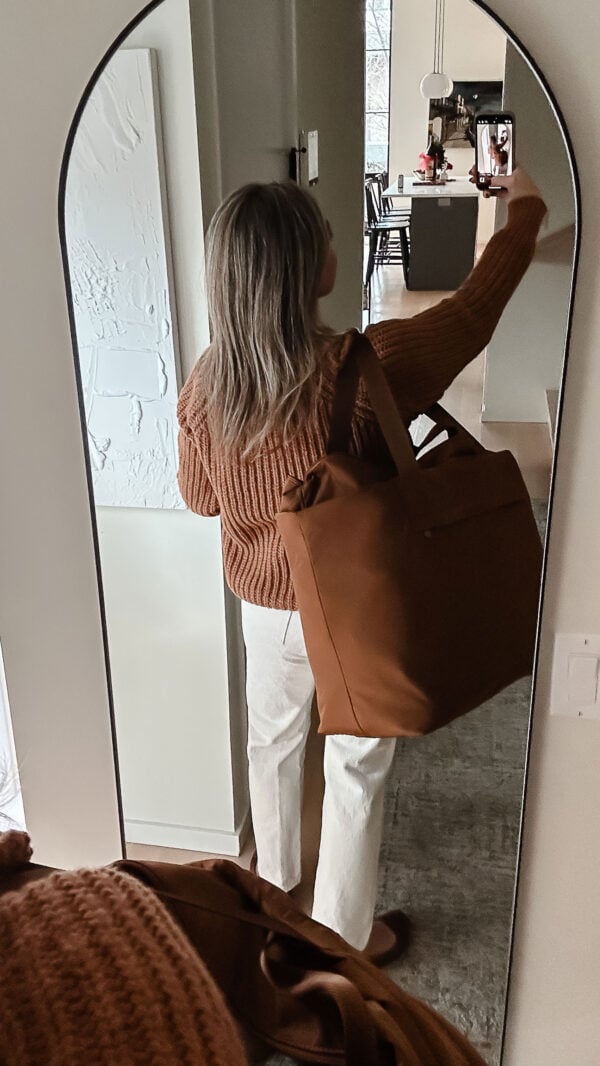 Travel blogger Jessica Sturdy showing the massive size of Away's Large Featherlight Tote Bag.