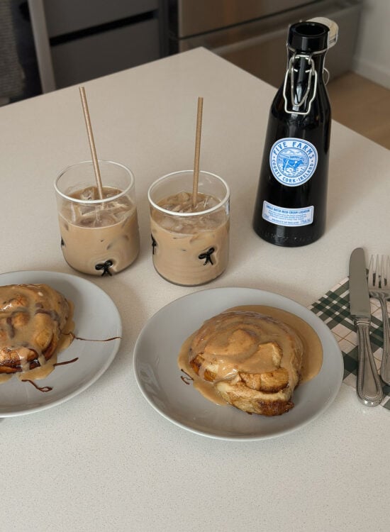 Freshly baked cinnamon roll with cream cheese frosting on a plate