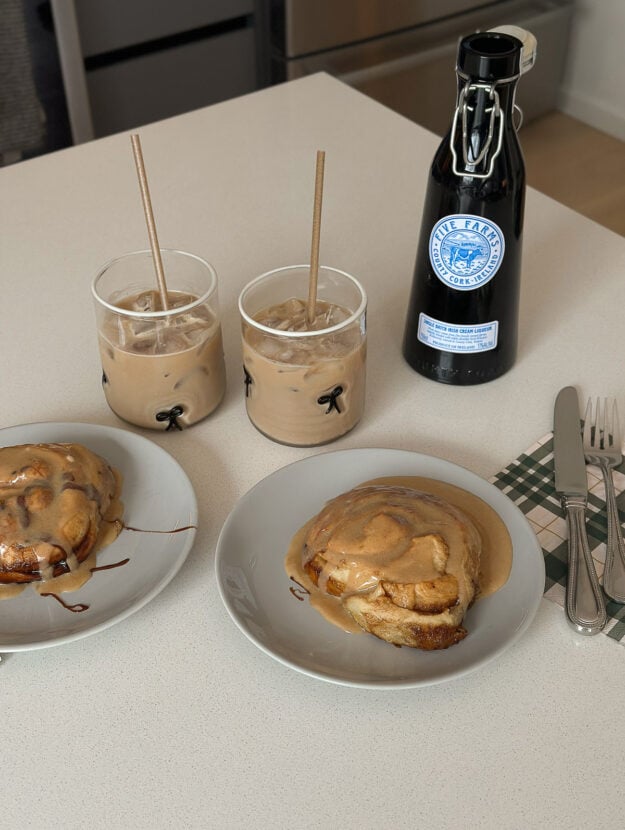 Freshly baked cinnamon roll with cream cheese frosting on a plate