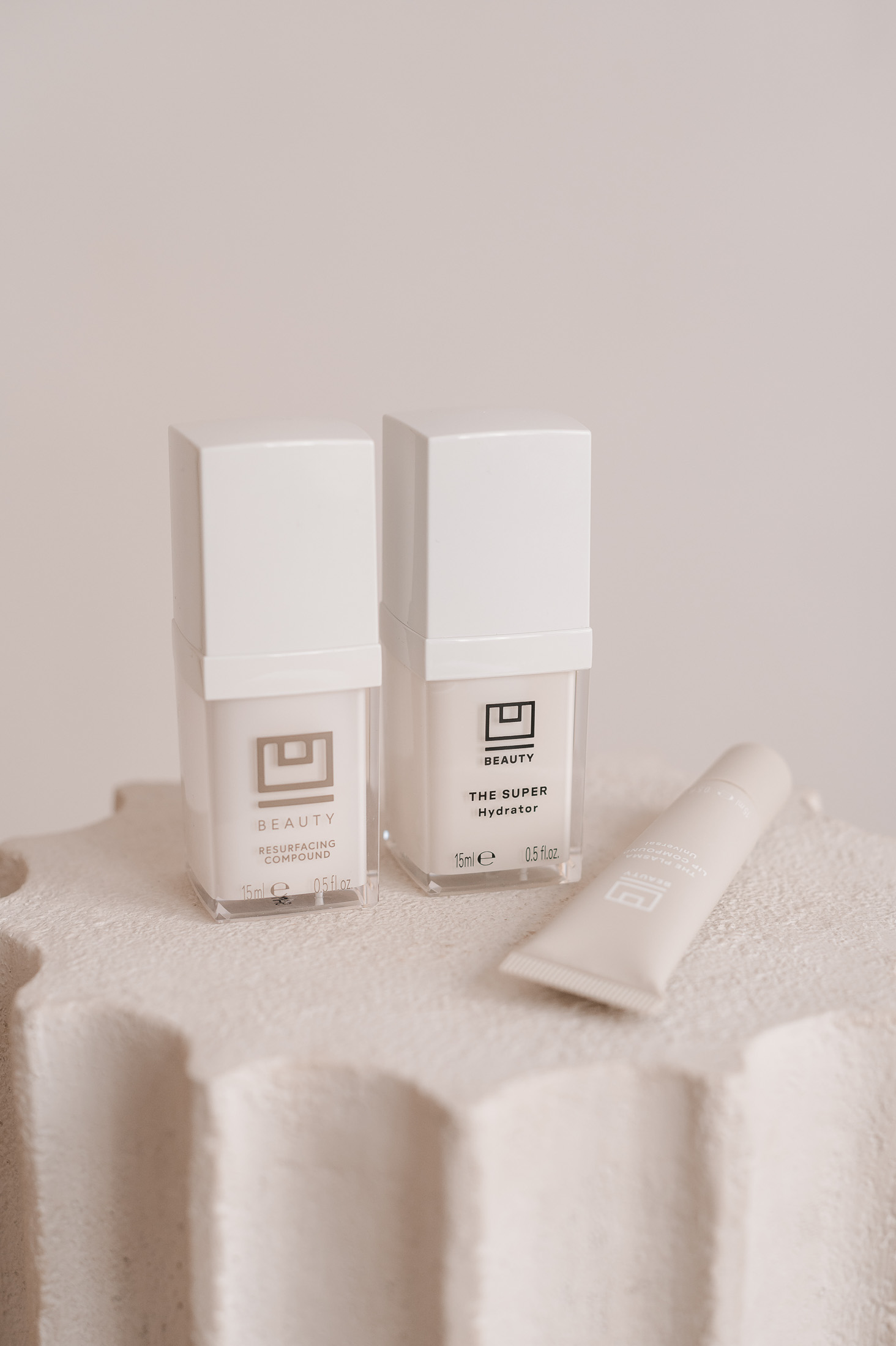 U Beauty Resurfacing Compound and Super Hydrator skincare bottles on a stone surface