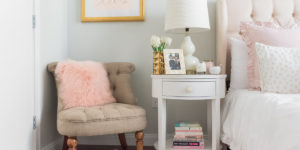 Blogger Jessica Sturdy of Bows & Sequins shares her Chicago Parisian-chic bedroom design. Un Deux Trois blush pink print, tufted linen chair, white faux shag animal skin rug, white round nightstand, white glass gourd lamps.
